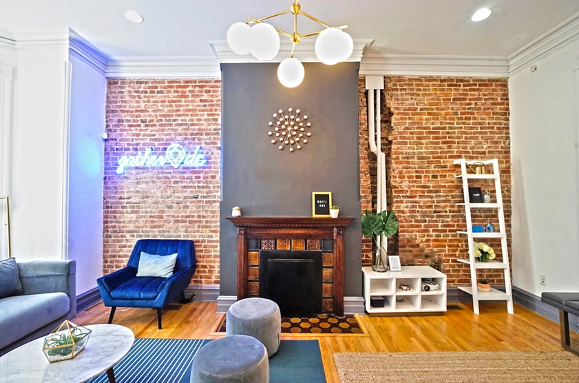 Image of GatherDC office's living room with fireplace, neon sign