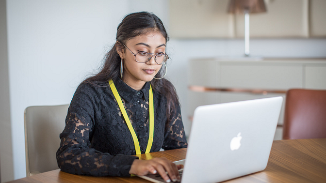 A student works in front of a laptop